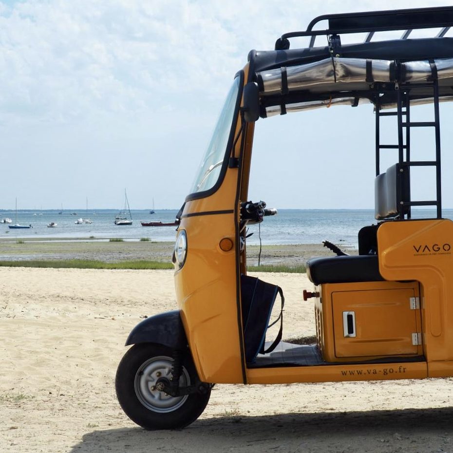 Tuk-tuk électrique VAGO jaune au bord de l’océan au Cap-Ferret